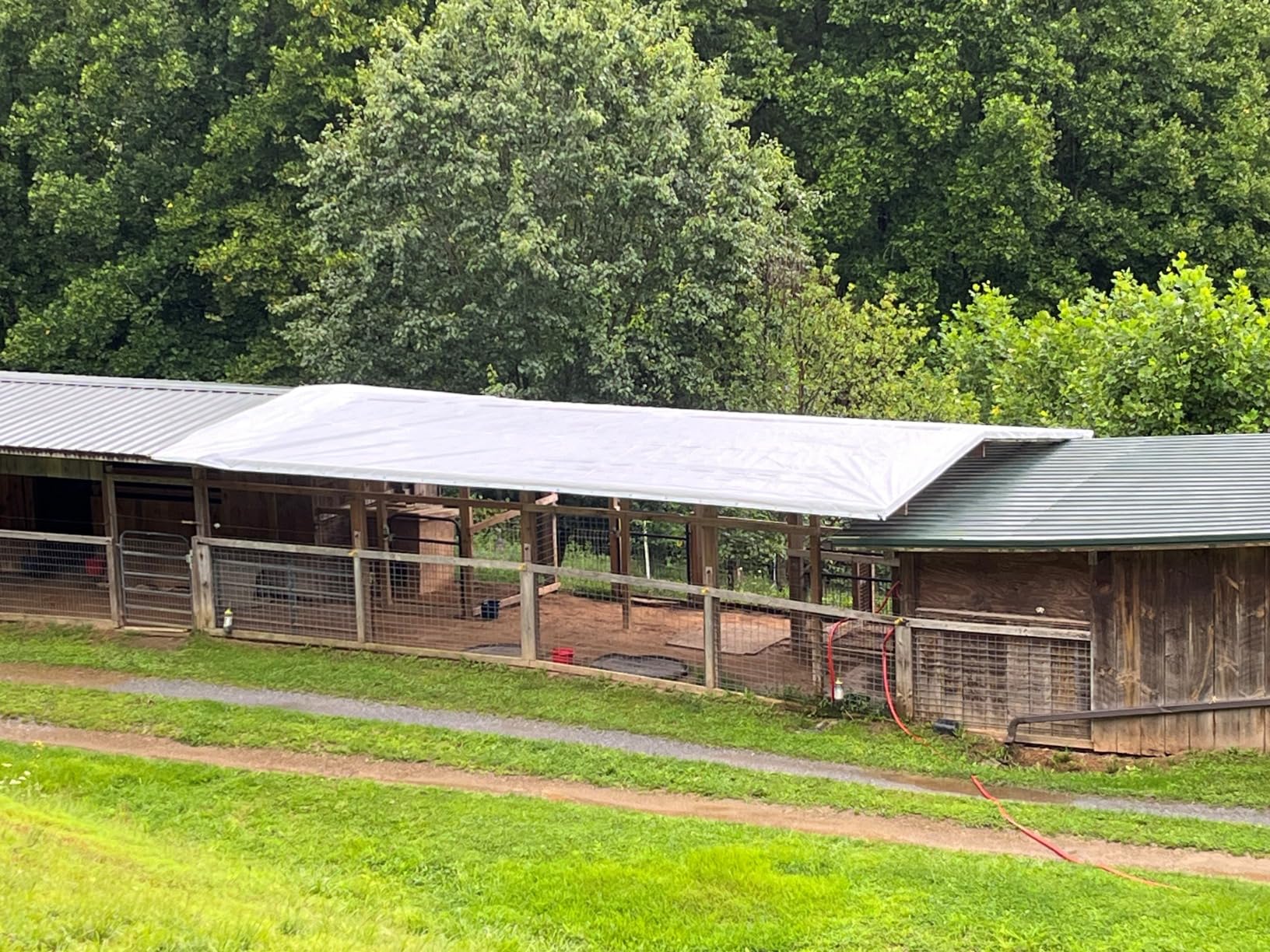 Tarp covering area between barns